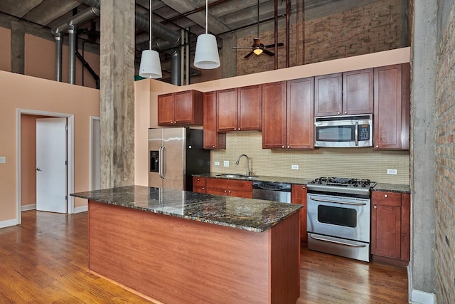2545 S Dearborn St Unit 323, Chicago, IL 60616 - kitchen with stainless steel appliances, a high ceiling, dark wood finished floors, decorative backsplash, and dark stone countertops
