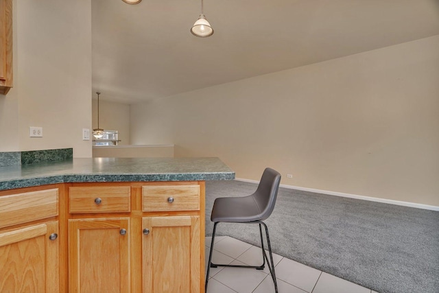 1109 Longwood Dr, Lisle, IL 60532 - kitchen with a peninsula, light carpet, light tile patterned floors, dark countertops, and a breakfast bar area