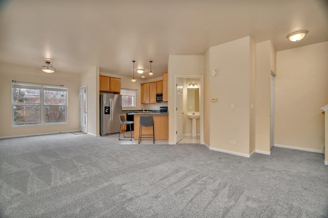 1109 Longwood Dr, Lisle, IL 60532 - kitchen featuring stainless steel fridge, open floor plan, light carpet, a breakfast bar, and decorative light fixtures