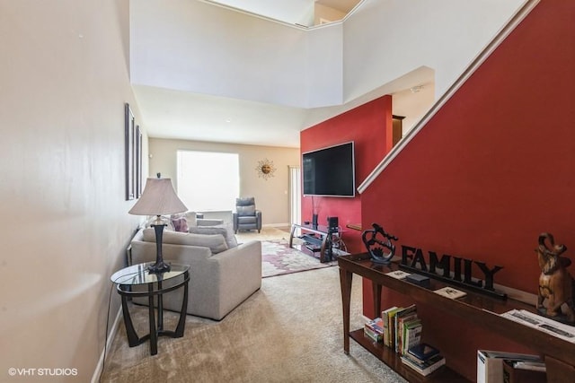 living room with carpet floors and a towering ceiling