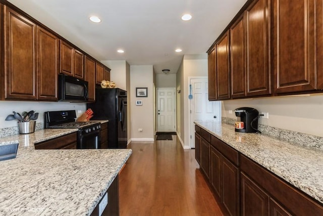kitchen with black appliances, dark wood-style floors, light stone counters, recessed lighting, and dark brown cabinets