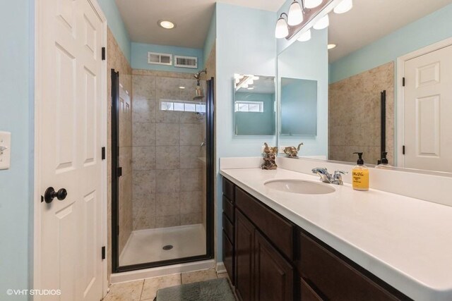 full bathroom featuring vanity, a shower stall, and tile patterned floors