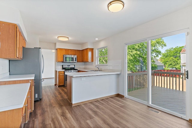 2315 Woodside Dr, Carpentersville, IL 60110 - kitchen featuring stainless steel appliances, dark wood-style floors, light countertops, and a peninsula