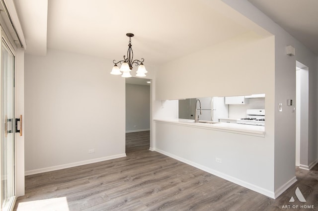 780 Buckingham Ct, Hoffman Estates, IL 60169 - kitchen with wood finished floors, white appliances, white cabinets, a chandelier, and pendant lighting