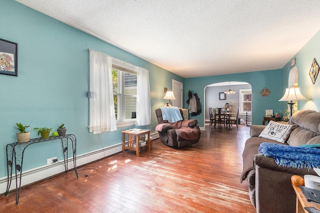 657 1st St, Crete, IL 60417 - living room featuring arched walkways, hardwood / wood-style flooring, a textured ceiling, and a baseboard radiator