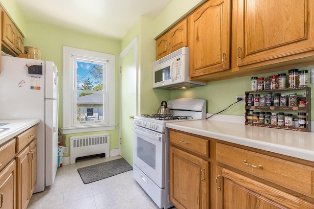 657 1st St, Crete, IL 60417 - kitchen with radiator, white appliances, light countertops, and brown cabinetry