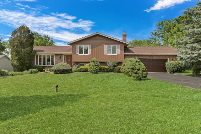 12976 W 21st St, Wadsworth, IL 60083 - split level home with an attached garage, driveway, a chimney, a front lawn, and brick siding