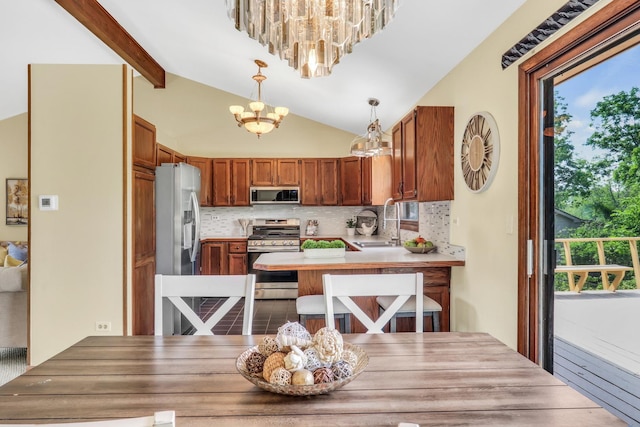 12976 W 21st St, Wadsworth, IL 60083 - kitchen with stainless steel appliances, a chandelier, tasteful backsplash, a peninsula, and brown cabinets