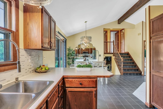 12976 W 21st St, Wadsworth, IL 60083 - kitchen with backsplash, a chandelier, a peninsula, hanging light fixtures, and light countertops