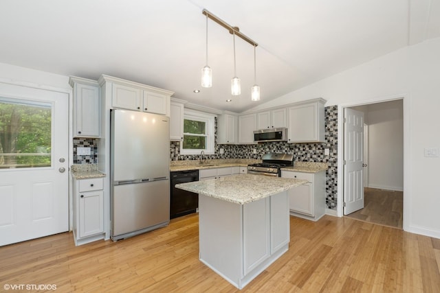 104 Hastings Way SW, Poplar Grove, IL 61065 - kitchen featuring stainless steel appliances, decorative backsplash, light wood-style flooring, lofted ceiling, and hanging light fixtures