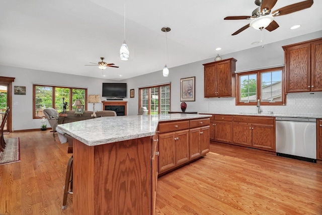 11186 188th Pl, Mokena, IL 60448 - kitchen with dishwasher, a ceiling fan, light wood finished floors, a fireplace, and tasteful backsplash