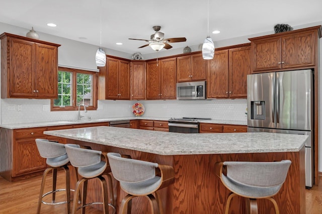 11186 188th Pl, Mokena, IL 60448 - kitchen featuring stainless steel appliances, brown cabinetry, light wood-type flooring, backsplash, and recessed lighting