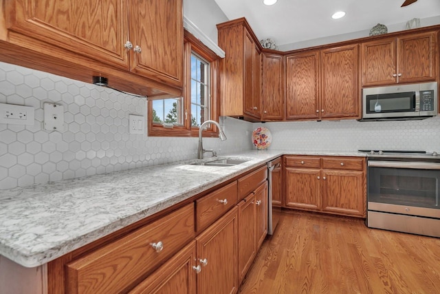 11186 188th Pl, Mokena, IL 60448 - kitchen featuring appliances with stainless steel finishes, decorative backsplash, light wood finished floors, brown cabinets, and recessed lighting