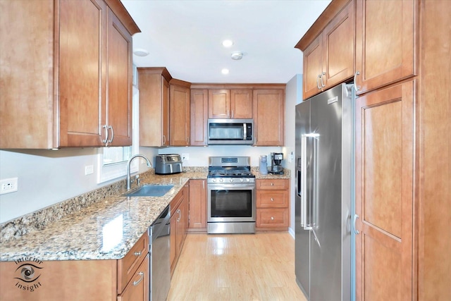 14727 Central Park Ave, Midlothian, IL 60445 - kitchen featuring appliances with stainless steel finishes, light wood-style flooring, brown cabinetry, light stone countertops, and recessed lighting