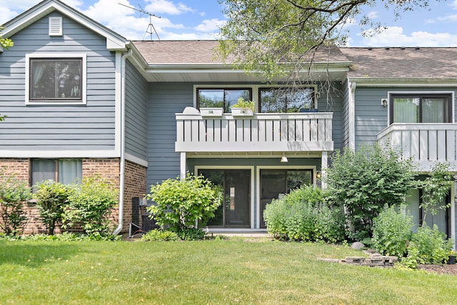 403 Sandalwood Ln Unit C1, Schaumburg, IL 60193 - back of property featuring a balcony, brick siding, a yard, and roof with shingles