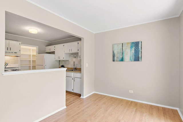 403 Sandalwood Ln Unit C1, Schaumburg, IL 60193 - kitchen with freestanding refrigerator, under cabinet range hood, light wood-type flooring, white cabinetry, and ornamental molding