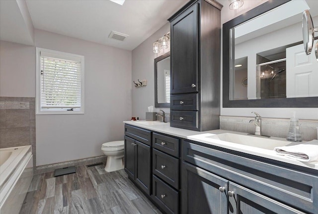 13907 W Big Run Ln, Homer Glen, IL 60491 - bathroom featuring double vanity, a garden tub, a tile shower, and wood finished floors