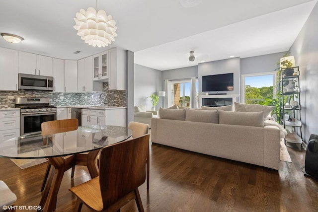 5862 N Lincoln Ave Unit 3A, Chicago, IL 60659 - kitchen featuring appliances with stainless steel finishes, decorative backsplash, white cabinetry, and dark wood finished floors