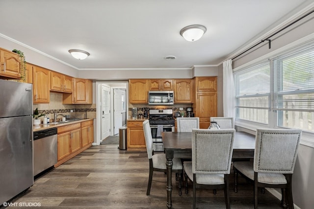 14928 Millard Ave, Midlothian, IL 60445 - kitchen with stainless steel appliances, dark wood-style floors, ornamental molding, tasteful backsplash, and light countertops