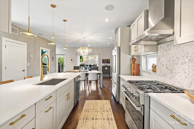 3800 N Christiana Ave, Chicago, IL 60618 - kitchen with wall chimney exhaust hood, premium appliances, light countertops, pendant lighting, and recessed lighting