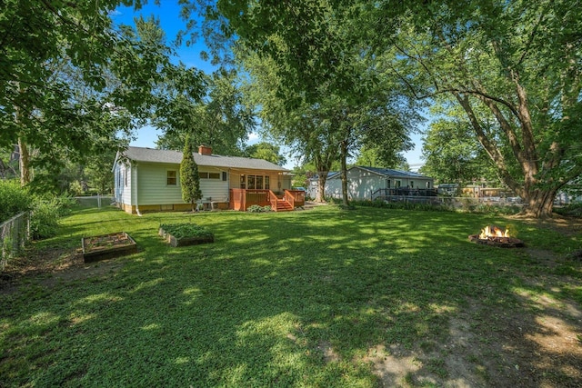 4606 Willow Ln, Mchenry, IL 60050 - fenced backyard featuring an outdoor fire pit, a vegetable garden, and a wooden deck