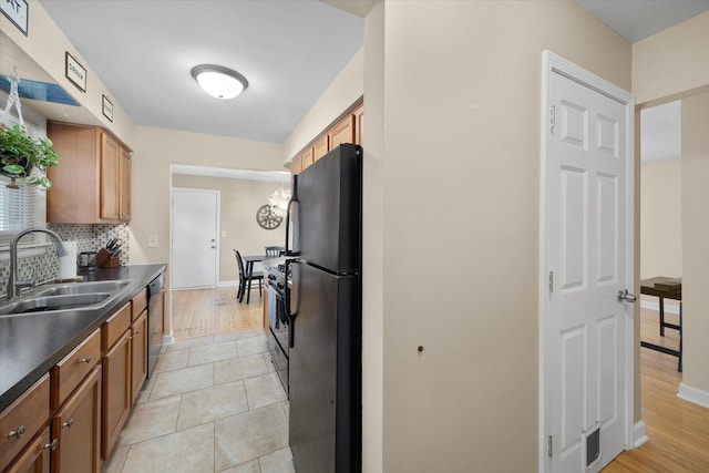 4606 Willow Ln, Mchenry, IL 60050 - kitchen with dark countertops, black appliances, brown cabinetry, and decorative backsplash