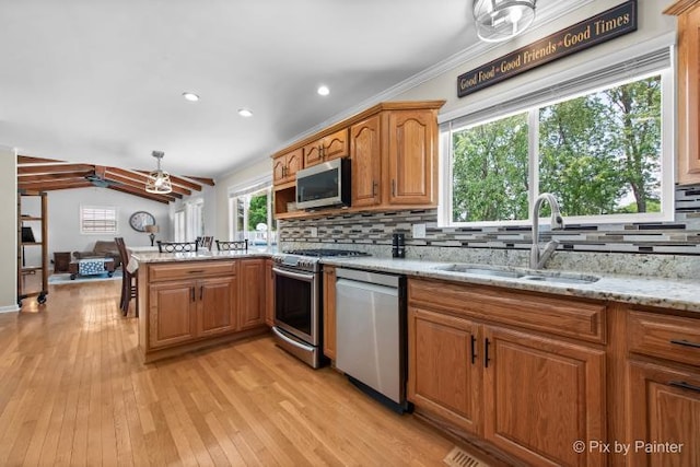 987 Split Rail Dr, Carol Stream, IL 60188 - kitchen with appliances with stainless steel finishes, a peninsula, backsplash, light wood-style floors, and light stone counters
