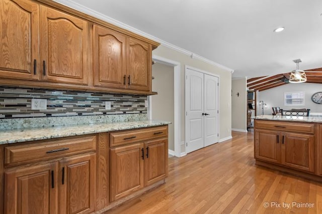 987 Split Rail Dr, Carol Stream, IL 60188 - kitchen with backsplash, light wood-type flooring, brown cabinetry, light stone countertops, and lofted ceiling