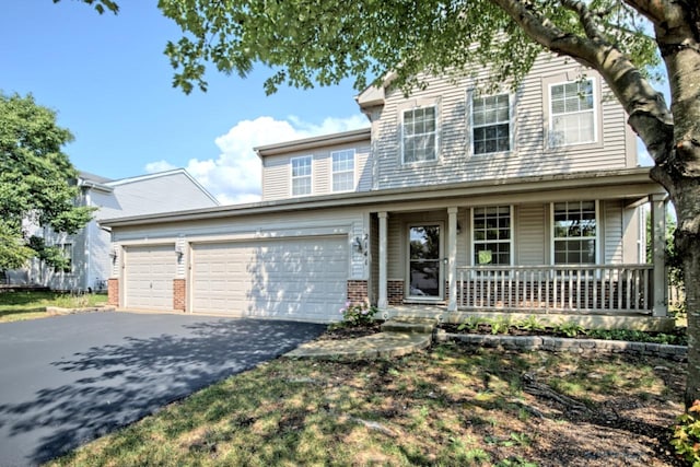 2141 Bluemist Dr, Aurora, IL 60504 - traditional-style home with covered porch, driveway, a garage, and brick siding
