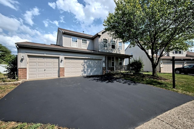 2141 Bluemist Dr, Aurora, IL 60504 - traditional-style home with asphalt driveway, brick siding, a porch, and an attached garage