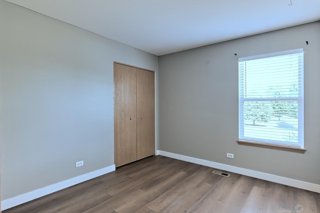 2141 Bluemist Dr, Aurora, IL 60504 - unfurnished bedroom featuring wood finished floors and a closet