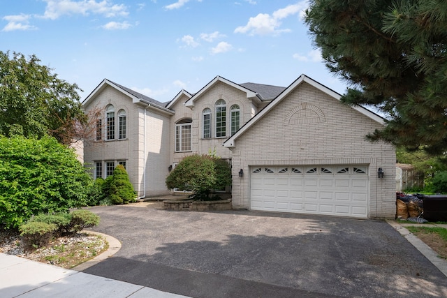 201 E White Oak St, Arlington Heights, IL 60005 - view of front of property featuring asphalt driveway, brick siding, and a garage