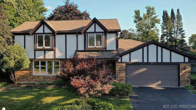 1054 Maple Ln, Batavia, IL 60510 - tudor house with brick siding, asphalt driveway, an attached garage, a shingled roof, and a front yard