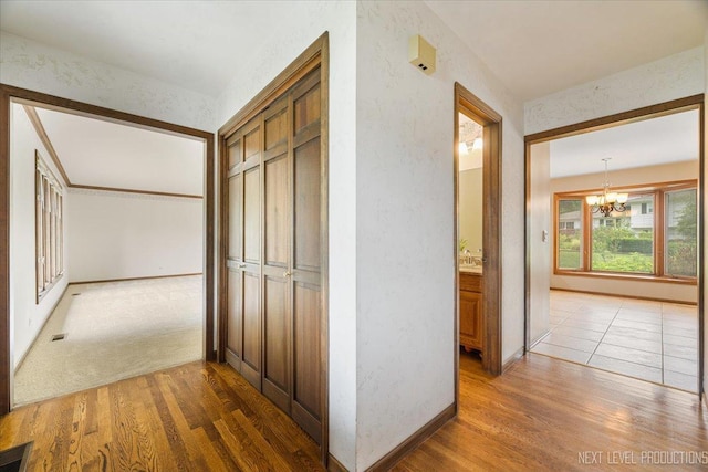 1054 Maple Ln, Batavia, IL 60510 - hallway featuring a chandelier and light wood-style flooring