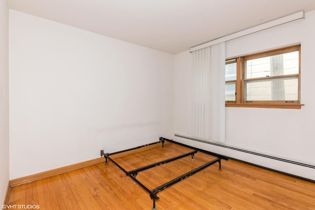7268 W Thorndale Ave Unit 8A, Chicago, IL 60631 - unfurnished bedroom featuring a baseboard radiator and wood finished floors