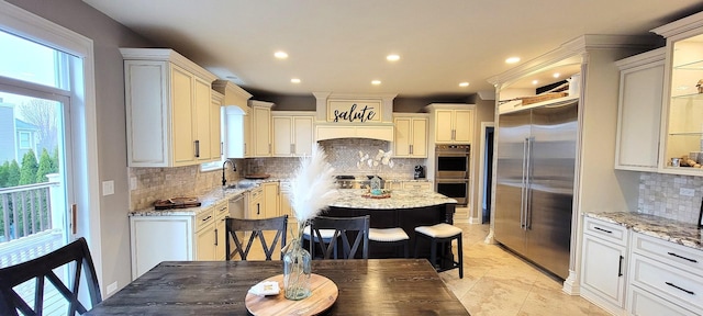 3004 Wayland Ave, Elgin, IL 60124 - kitchen featuring appliances with stainless steel finishes, tasteful backsplash, light stone countertops, a kitchen island, and recessed lighting
