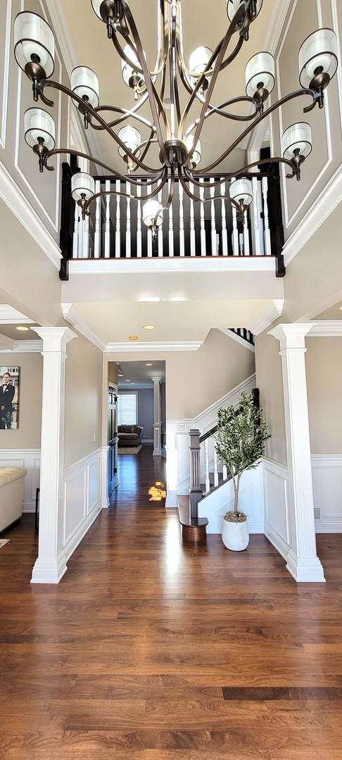 3004 Wayland Ave, Elgin, IL 60124 - foyer entrance with decorative columns, a towering ceiling, stairs, a decorative wall, and wood finished floors