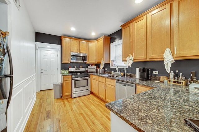 4825 N Karlov Ave, Chicago, IL 60630 - kitchen with stainless steel appliances, light wood-style flooring, recessed lighting, and dark stone counters