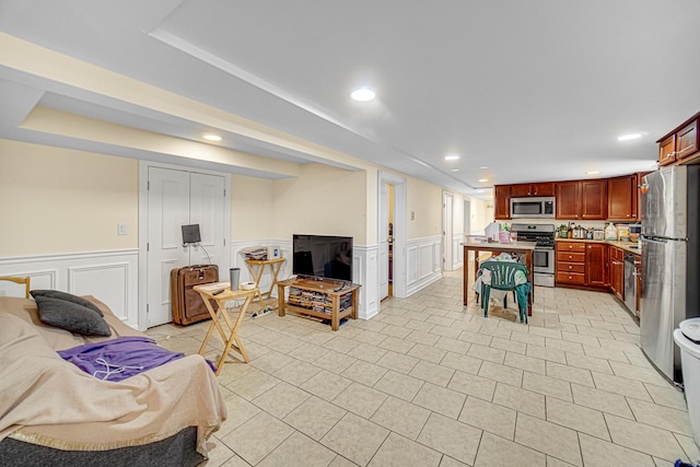 4825 N Karlov Ave, Chicago, IL 60630 - kitchen with stainless steel appliances, a wainscoted wall, a center island, a decorative wall, and reddish brown cabinets