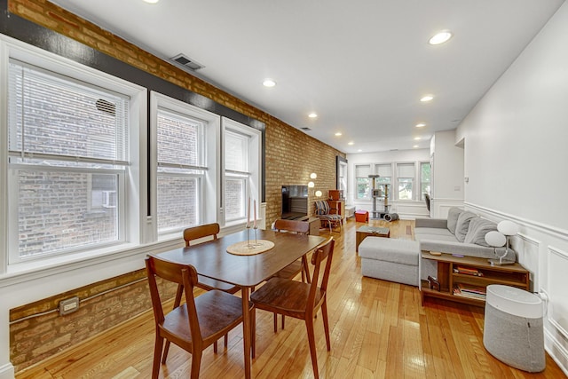 4825 N Karlov Ave, Chicago, IL 60630 - dining room with light wood-style floors, wainscoting, brick wall, recessed lighting, and a decorative wall