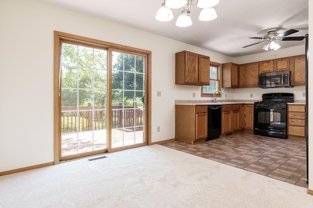 5971 Whispering Way, Loves Park, IL 61111 - kitchen with black appliances, brown cabinets, a chandelier, light countertops, and light colored carpet