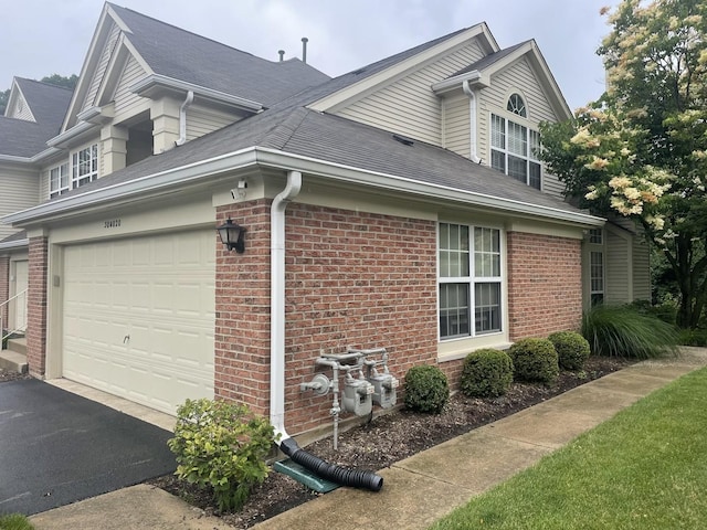 30W020 Mayfair Ct Unit 20, Warrenville, IL 60555 - view of side of home featuring brick siding, asphalt driveway, and a shingled roof