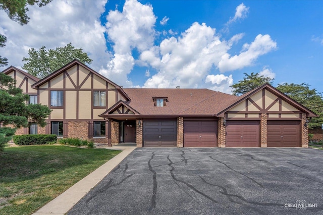 1703 Lakecliffe Dr Unit D, Wheaton, IL 60189 - tudor-style house with brick siding, stucco siding, a front lawn, driveway, and a garage