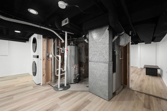 638 S Cuyler Ave, Oak Park, IL 60304 - basement featuring estacked washer and dryer, water heater, wood finished floors, and heating unit