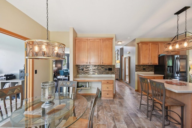 2590 Hennig Rd, Hampshire, IL 60140 - kitchen featuring refrigerator with ice dispenser, light countertops, backsplash, dark wood-style floors, and hanging light fixtures