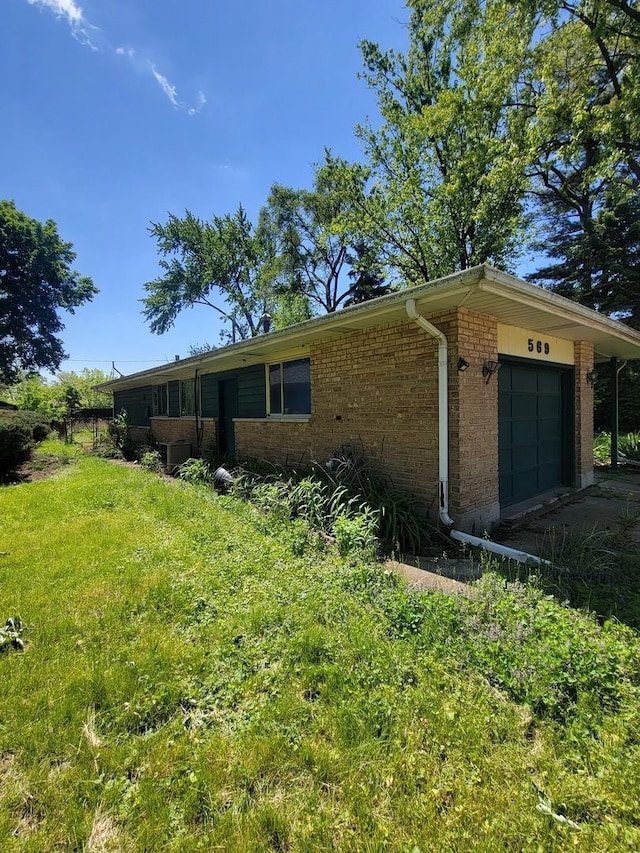 569 Lakewood Blvd, Park Forest, IL 60466 - view of side of home with an attached garage, brick siding, and driveway