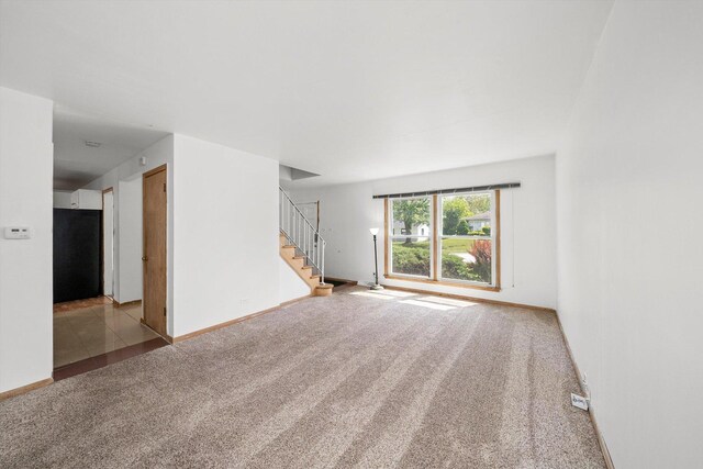 17714 Dogwood Ln, Hazel Crest, IL 60429 - unfurnished living room with carpet flooring and stairway