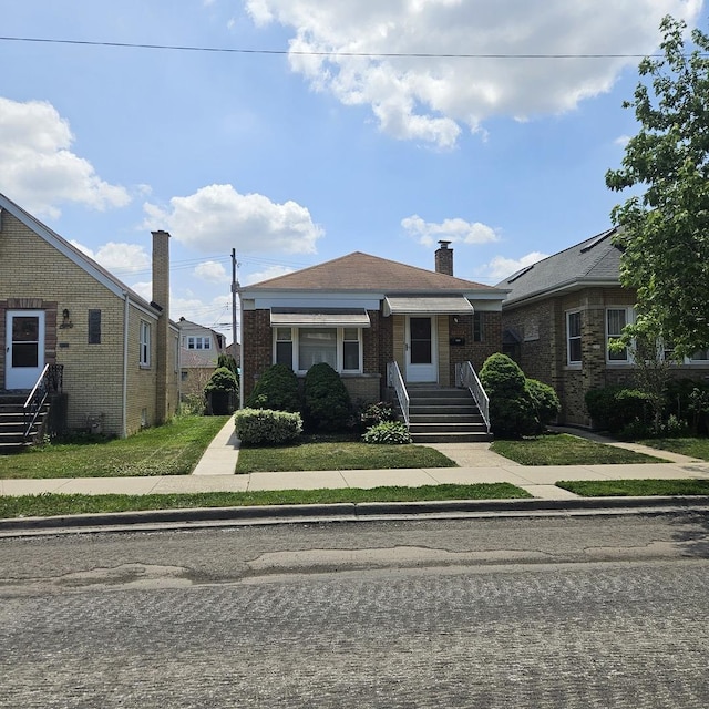 5823 W Addison St, Chicago, IL 60634 - bungalow-style home with brick siding, a chimney, and entry steps