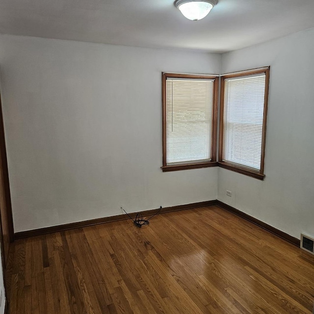 5823 W Addison St, Chicago, IL 60634 - spare room featuring dark wood-type flooring and baseboards