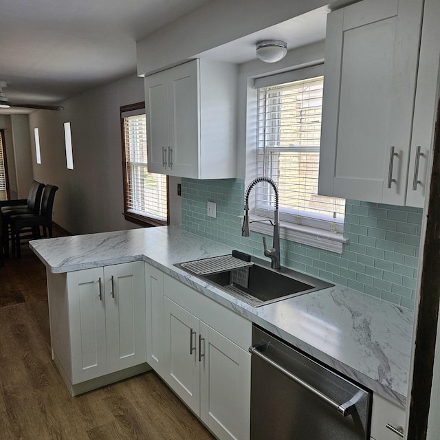 5823 W Addison St, Chicago, IL 60634 - kitchen featuring stainless steel dishwasher, a peninsula, white cabinetry, dark wood finished floors, and tasteful backsplash